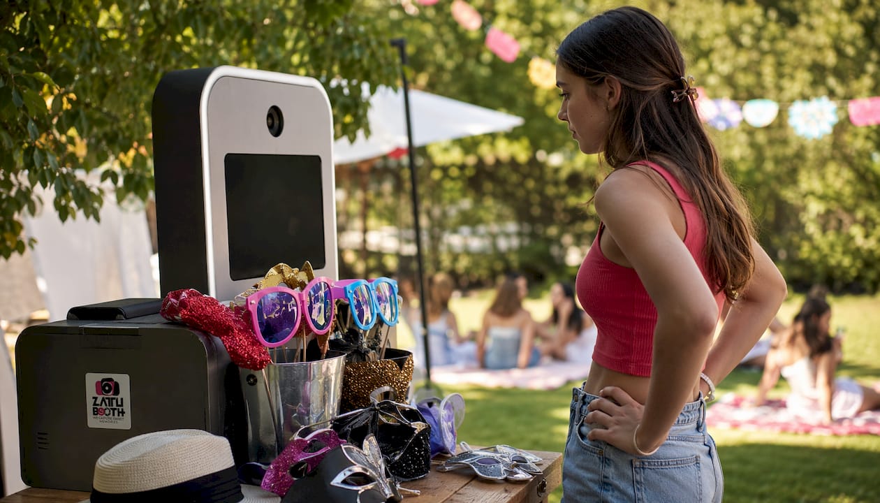 Open-air photo booth with props and teen guest